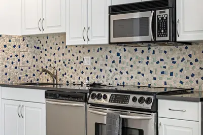 a kitchen with a stove and a microwave at Las Olas Blvd Waterfront Apt in Fort Lauderdale