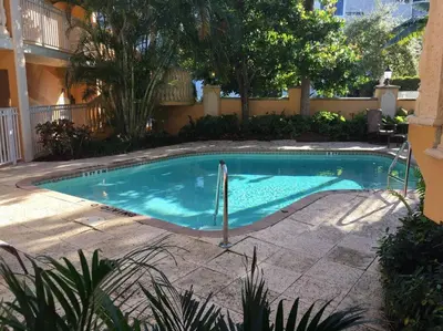 a small swimming pool in a yard with trees at Las Olas Blvd Waterfront Apt in Fort Lauderdale