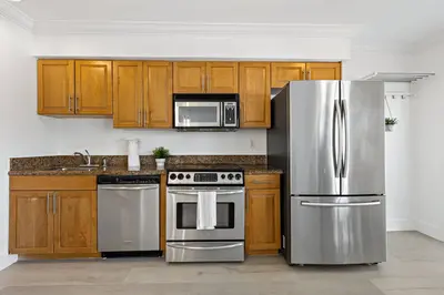 a kitchen with wooden cabinets and stainless steel appliances at Las Olas Blvd Exclusive Apt with waterview in Fort Lauderdale
