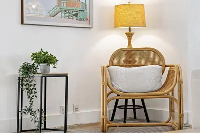 a wicker chair with a lamp on it next to a table at Spacious Beach Apt in Las Olas Blvd in Fort Lauderdale