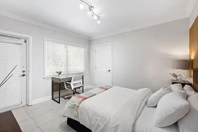 a white bedroom with a bed and a desk at Relaxing Beach Apt in las Olas Blvd in Fort Lauderdale
