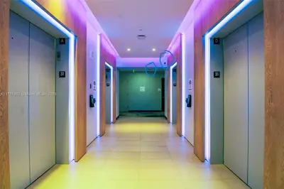 a hallway with pink and green walls and a long corridor at Huge Studio POOL & GYM - Explore Miami's Heat in Miami