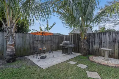a backyard with a grill and a table with an umbrella at 7-Person Luxury Spa, Fenced Paradise, Beach Vibes in Pembroke Pines