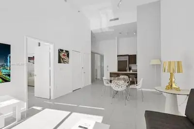 a white living room with a table and chairs at 28th Floor Icon Brickell Penthouse with City Views in Miami