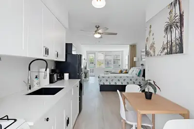 a kitchen and living room with a bed and a table at North Shore Oasis - Steps to Miami Beach Bliss in Miami Beach