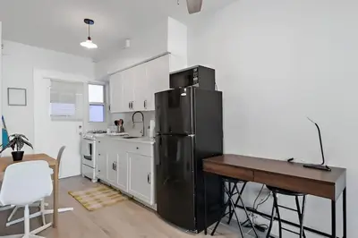 a kitchen with a black refrigerator and a table at North Shore Oasis - Steps to Miami Beach Bliss in Miami Beach