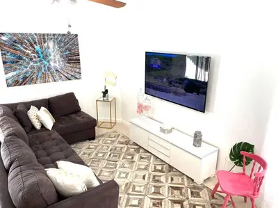 a living room with a couch and a tv at ZION Miami Design District 2 Bedroom amongst the trees! in Miami