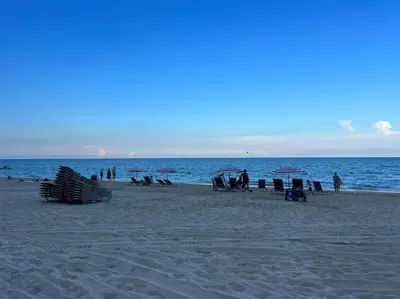 a group of people sitting on a beach at Compact & Comfy, BeachWalk Studio for Small Groups in Hallandale Beach