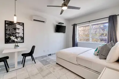 a bedroom with a bed and a desk and a window at Best location by the Beach ! Free WiFi - TV - All amenities 103 in Miami Beach