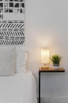 a bedroom with a bed and a table with a lamp at Lake Ridge Villa in Fort Lauderdale