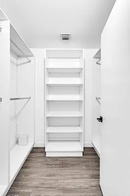 a white walk in closet with white shelves at Amazing 2 Bedroom Unit In Doral Miami With Free Parking in Hialeah Gardens