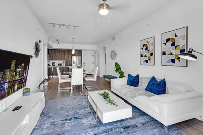 a living room with a white couch and blue pillows at Amazing 2 Bedroom Unit In Doral Miami With Free Parking in Hialeah Gardens