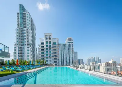 a swimming pool on the roof of a building with tall buildings at Sentral Alea Miami in Miami