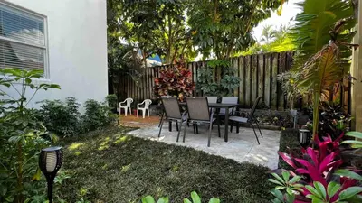 a backyard with a table and chairs and a fence at Charming 2 Bedroom Apartment in Victoria Park in Fort Lauderdale