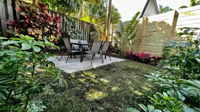 a patio with chairs and a table in a garden at Charming 2 Bedroom Apartment in Victoria Park in Fort Lauderdale