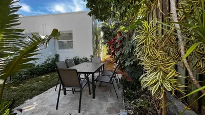 a table and chairs on a patio with plants at Charming 2 Bedroom Apartment in Victoria Park in Fort Lauderdale