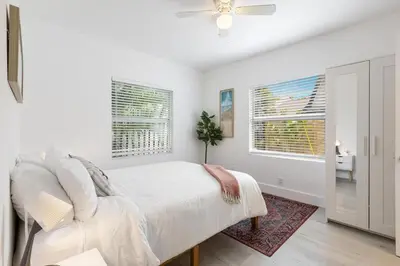 a white bedroom with a bed and a window at Charming 2 Bedroom Apartment in Victoria Park in Fort Lauderdale