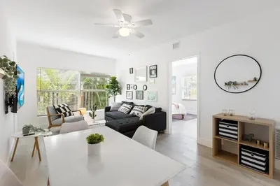 a white living room with a couch and a table at Charming 2 Bedroom Apartment in Victoria Park in Fort Lauderdale