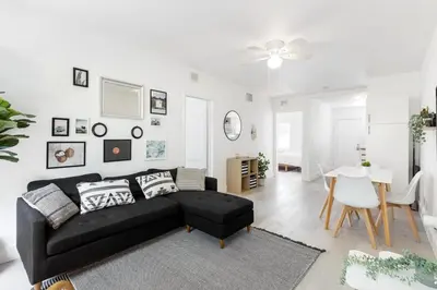 a living room with a black couch and a table at Charming 2 Bedroom Apartment in Victoria Park in Fort Lauderdale
