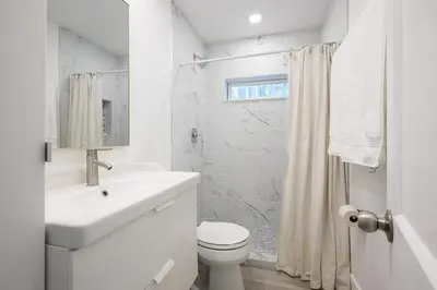 a white bathroom with a sink and a toilet at Beautiful And Comfortable Apt in Victoria Park in Fort Lauderdale