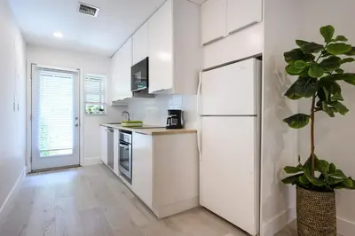 a kitchen with white cabinets and a white refrigerator at Beautiful And Comfortable Apt in Victoria Park in Fort Lauderdale