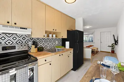 a kitchen with wooden cabinets and a black refrigerator at Lovely Rental Unit with free Parking on Premises in Fort Lauderdale