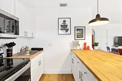 a kitchen with white cabinets and a wooden counter top at Lovely 2 BR condo with free parking on premises in Fort Lauderdale