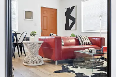 a red leather couch in a living room with a table at Lovely 2 BR condo with free parking on premises in Fort Lauderdale