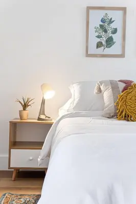 a bedroom with a white bed and a nightstand with a lamp at Lovely 2 BR condo in Sailboat Bend in Fort Lauderdale