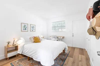 a white bedroom with a bed and a desk at Lovely 2 BR condo in Sailboat Bend in Fort Lauderdale