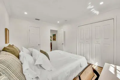 a bedroom with white walls and a bed with white sheets at Beautiful 2 BR Apartment - Bright and Spacious in Fort Lauderdale