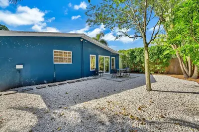 a blue house with a tree in front of it at Beautiful 2 BR Apartment - Bright and Spacious in Fort Lauderdale