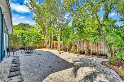 a backyard with a table and chairs and a fence at Beautiful 2 BR Apartment - Bright and Spacious in Fort Lauderdale