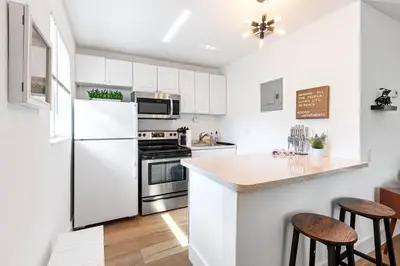 a kitchen with white cabinets and a white refrigerator at Musicians Lounge - 2 BR with parking asssigned in Fort Lauderdale
