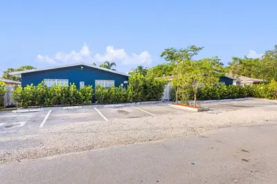 a parking lot in front of a blue building at Musicians Lounge - 2 BR with parking asssigned in Fort Lauderdale