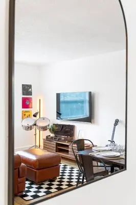a living room with a table and chairs and a mirror at Musicians Lounge - 2 BR with parking asssigned in Fort Lauderdale