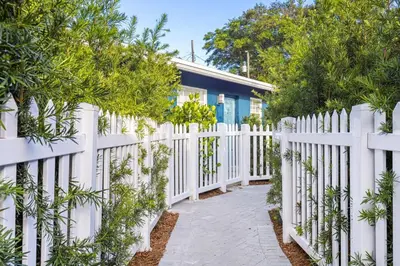 a white fence in front of a house at Stylish 2 BR Condo - Free Parking on Premises in Fort Lauderdale