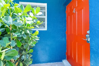 a blue house with a red door and a window at Bright and Spacious 2 BR Apartment in Fort Lauderdale