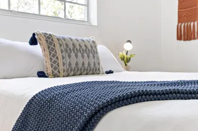 a bed with a blue blanket on top of it at Bright and Spacious 2 BR Apartment in Fort Lauderdale