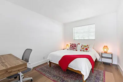 a white bedroom with a bed and a desk at Stylish 2 BR condo - close to Riverwalk in Fort Lauderdale
