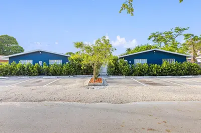a parking lot in front of two blue buildings at The Yellow Submarine @Sailboat Bend in Fort Lauderdale