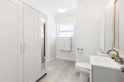 a white bathroom with a toilet and a sink at Victoria Park Unique Studio close to Las Olas Blvd in Fort Lauderdale