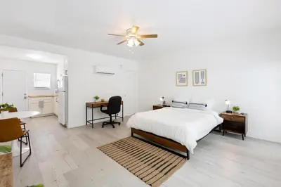 a bedroom with a bed and a table and a refrigerator at Victoria Park Unique Studio close to Las Olas Blvd in Fort Lauderdale
