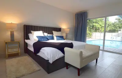 a bedroom with a bed and a chair and a pool at Villa Cristina in Miami in Miami