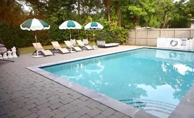 a swimming pool with lounge chairs and umbrellas at Villa Cristina in Miami in Miami