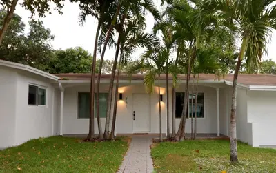a white house with palm trees in front of it at Villa Cristina in Miami in Miami