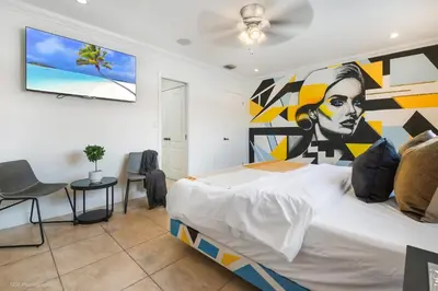 a bedroom with a large bed with a painting on the wall at Le Femme Paradise -Htd Pool, Mini Golf, 5 Bedrooms, Jacuzzi, Game Room, BBQ,Pickleball in Miami