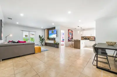 a living room with a couch and a table and a kitchen at Le Femme Paradise -Htd Pool, Mini Golf, 5 Bedrooms, Jacuzzi, Game Room, BBQ,Pickleball in Miami