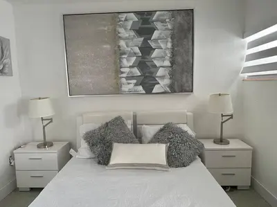 a bedroom with a bed with pillows and a painting at Villa Clara SUITE - Little Havana in Miami