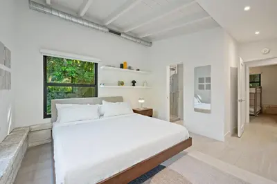 a white bedroom with a large bed and a window at Coconut Grove Mid-Century Jungle Oasis in Miami